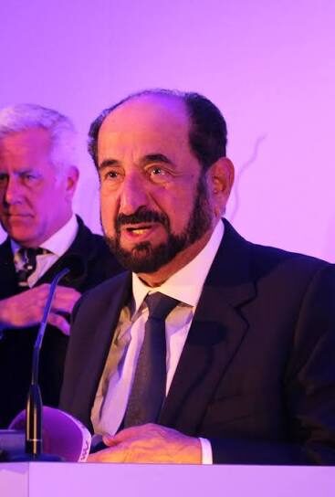 Sultan Muhammad Al Qasimi speaking from a podium at an international conference