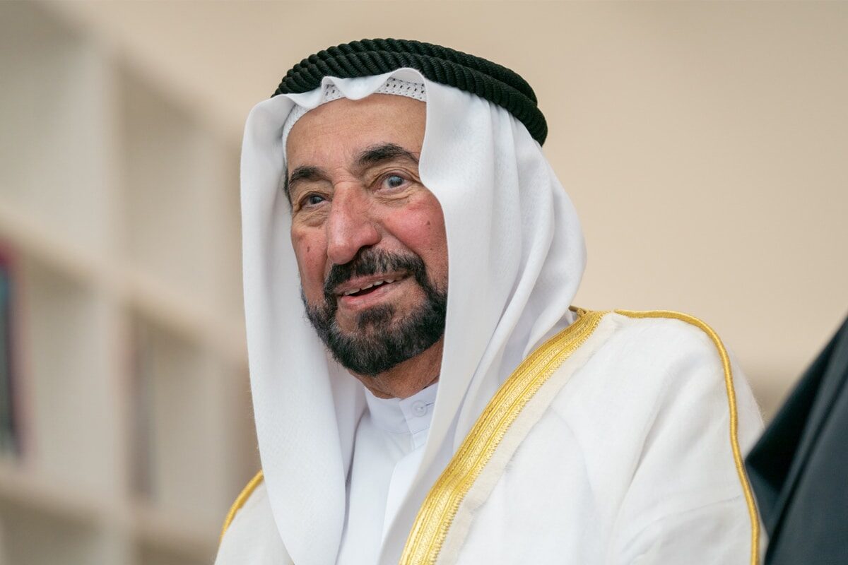Sultan Muhammad Al Qasimi in conversation in an office lined with bookshelves