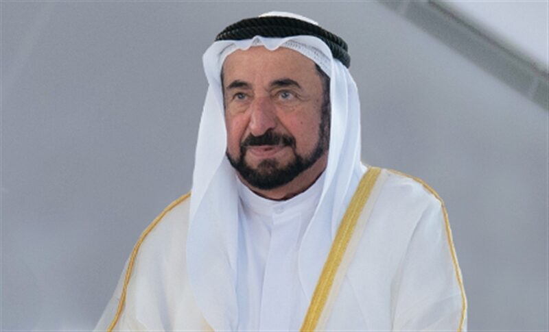 Portrait of Sultan Muhammad Al Qasimi in white kandura against a light background